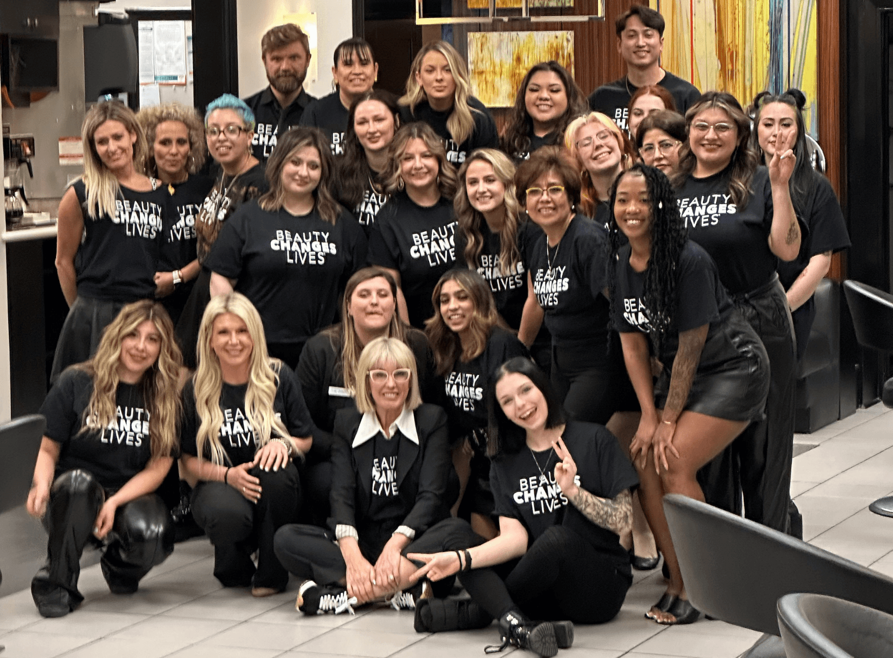 The Beauty Changes Lives team huddles together for a group photo.