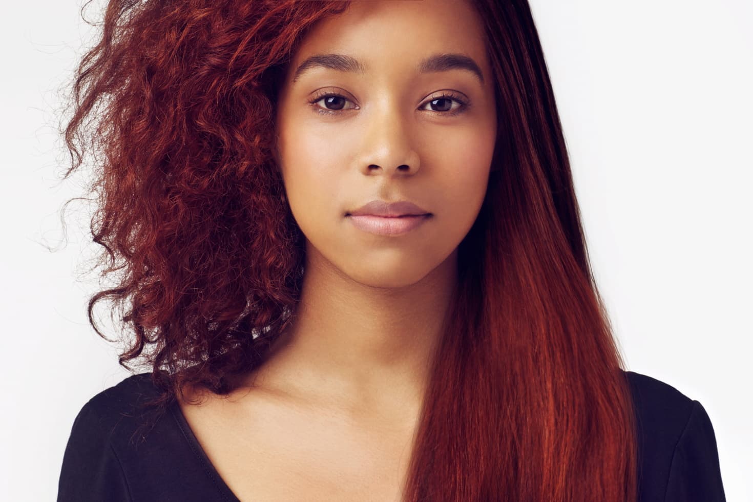 A woman has pin-straight hair on one side and messy waves on the other. She looks great either way.