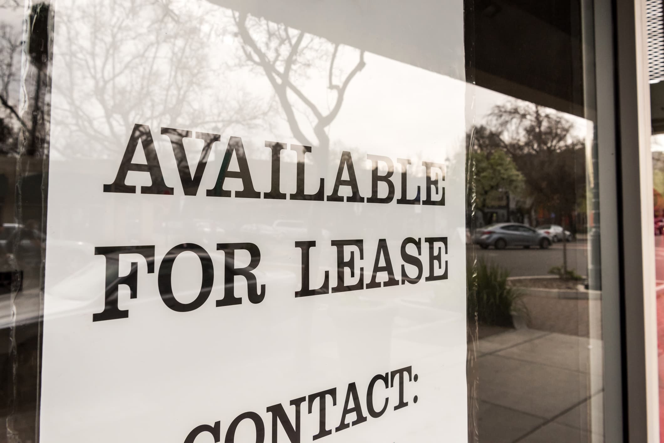 A sign in a window reads, "Available for lease. Contact:"