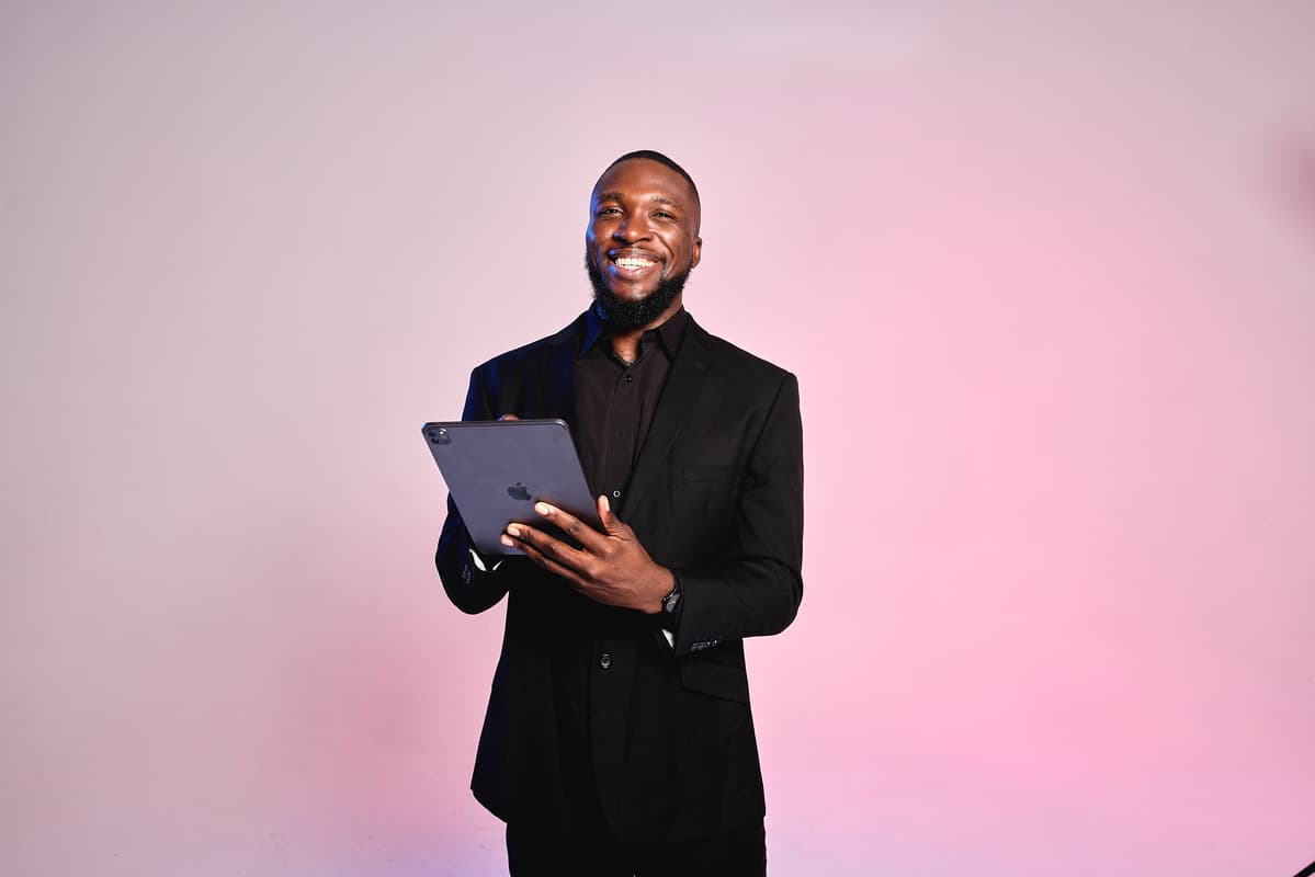 A medspa manager holds a tablet, smiling as he welcomes medspa clients.